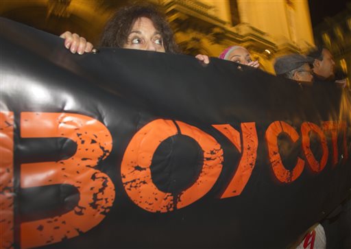 In this Wednesday, Oct. 31, 2012 file photo, French demonstrators and supporters of Palestinians hold a placard with the word "Boycott" during a demonstration in Paris, France. A campaign called BDS, which was started by Palestinian activists 10 years ago to boycott Israel, has grown into a worldwide network of thousands of volunteers lobbying corporations, artists and academic institutions to sever ties with Israel. (AP Photo/Jacques Brinon, File)