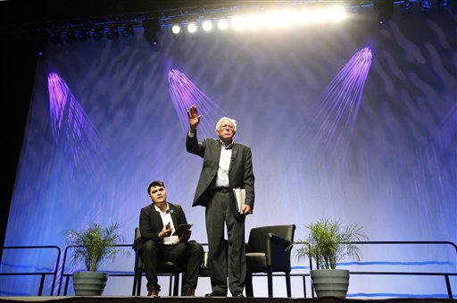Democratic presidential candidate Sen. Bernie Sanders, I-Vt., tries to speak as he is shouted down by protesters as moderator Jose Vargas watches at left, Saturday, July 18, 2015, at a Netroots Nation town hall meeting in Phoenix. (AP Photo/Ross D. Franklin)