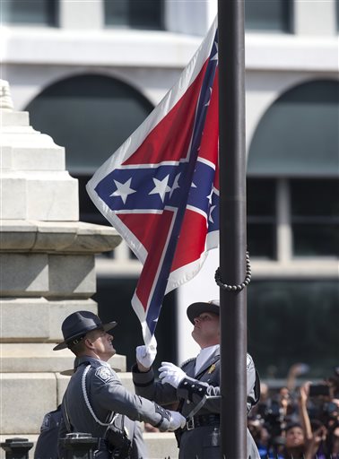 An honor guard from the South Carolina Highway patrol removes the Confederate battle flag from the Capitol grounds in Columbia, S.C., ending its 54-year presence there, on Friday, July 10, 2015. (AP Photo/John Bazemore)