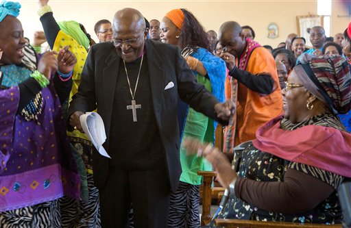 In this Saturday, July 4, 2015 file photo  retired Anglican Archbishop Desmond Tutu, centre, breaks into dance after renewing his wedding vows to his wife of 60 years, Leah, right, during a service in Soweto, Johannesburg. Tutu will spend a second night in a Cape Town hospital, Wednesday July 15, 2015, as he continues to receive treatment for a persistent infection. (AP Photo/File)