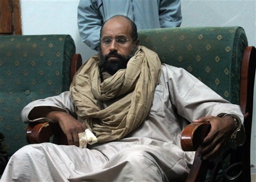 In this Saturday, Nov. 19, 2011 file photo, Seif al-Islam is seen after his capture in the custody of revolutionary fighters in Zintan. A court in the Libyan capital has sentenced Seif al-Islam to death over killings during the country's 2011 uprising. The Tripoli court handed down the sentence Tuesday for Seif al-Islam, who is currently being held by a militia that refuses to hand him over to the central government. The court sentenced eight others to death as well, including former Libyan spy chief Abdullah al-Senoussi. (AP Photo/Ammar El-Darwish, File)