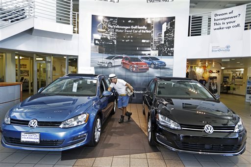 In this Thursday, July 2, 2015, photo, customer Armando Barillas checks the interior of a vehicle for sale at the New Century Volkswagen dealership in Glendale, Calif. Volkswagen overtook Toyota in global vehicle sales for January-June, the first time the German automaker has come out top in the intensely competitive tallies. (AP Photo/Damian Dovarganes)