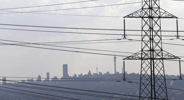 In this photo taken Tuesday, March 10, 2015 electricity pylons cross the skyline of Johannesburg city, background. Rolling blackouts have become a common drudgery in the country with the government warning that forced outages will will continue for years. (AP Photo/Themba Hadebe)