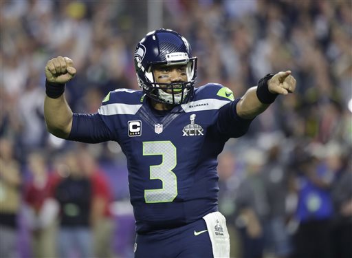 In this Feb. 1, 2015, file photo, Seattle Seahawks quarterback Russell Wilson celebrates after throwing a touchdown pass during the first half of NFL Super Bowl XLIX football game against the New England Patriots in Glendale, Ariz. Russell Wilson is sticking around with the Seattle Seahawks.  Wilson tweeted Friday morning, July 31, 2015, that he has agreed to a four-year contract extension with the Seahawks, keeping him with the franchise that took him in the third round of the 2012 draft and watched him become one of the most successful young quarterbacks in NFL history. (AP Photo/David Goldman)