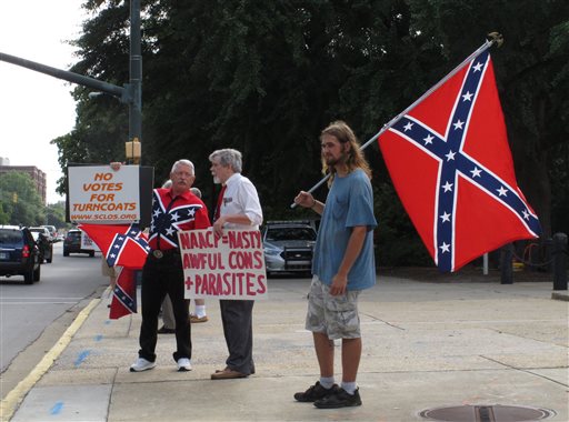 William Cheek, left, Nelson Waller, center, and Jim Collins, right, protest proposals to remove the Confederate flag from the grounds of the South Carolina Statehouse on Monday, July 6, 2015, in Columbia, S.C. The General Assembly returns Monday to discuss Gov. Nikki Haley's budget vetoes and what to do with the rebel flag that has flown over some part of the Statehouse for more than 50 years. (AP Photo/Jeffrey Collins)