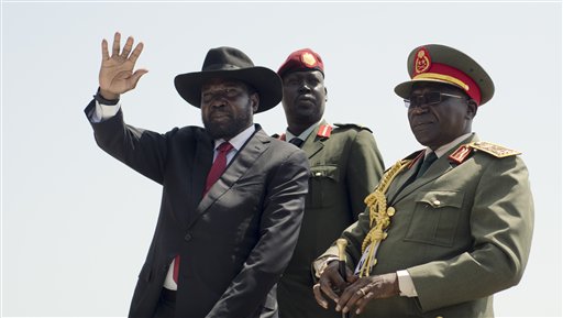 South Sudan's President Salva Kiir, left, accompanied by army chief of staff Paul Malong Awan, right, waves during an independence day ceremony in the capital Juba, South Sudan, Thursday, July 9, 2015. South Sudan marked four years of independence from Sudan on Thursday, but the celebrations were tempered by concerns about ongoing violence and the threat of famine. (AP Photo/Jason Patinkin)