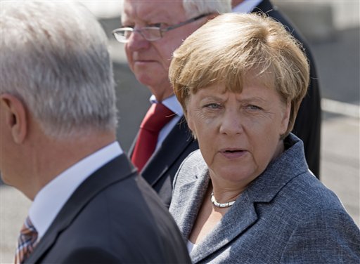 German Chancellor Angela Merkel arrives prior her visit  to a refugee shelter  that was attacked by far-right protesters over the weekend in Heidenau, eastern Germany, Wednesday, Aug. 26, 2015. Dozens of police were injured when a far-right mob hurled bottles and fireworks at officers in an attempt to prevent asylum seekers from moving into the former hardware store at the weekend. Germany has seen a surge in refugees coming to the country this year, with officials predicting the number could reach 800,000 by the end of 2015.  (AP Photo/Jens Meyer)