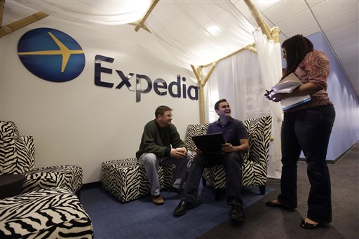In this Tuesday, Jan. 15, 2013, file photo, Expedia analytics team workers Mike Brown, left, Saurin Pandya and Prashanti Tata chat in an alcove set up for employees, in Bellevue, Wash. The American Hotel & Lodging Association on Thursday, Aug. 6, 2015 issued a statement announcing its opposition to the proposed combination of travel booking sites Expedia and Orbitz, saying that the deal would mean higher prices for vacationers and larger fees for hotel owners. (AP Photo/Elaine Thompson, File)