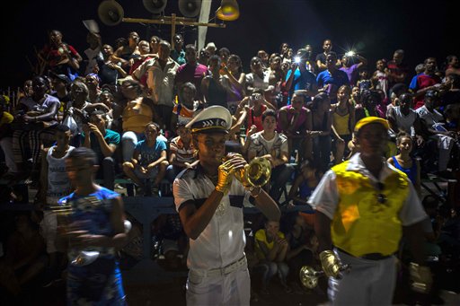 In this July 25, 2015 photo, a reveler plays the trumpet at the start of a carnival parade in Santiago, Cuba. Along with the new oceanfront Malecon and the restoration of homes in the citys historic center, the Cuban government has built a new theater and an artisanal brewpub as part of a broader reconstruction and improvement effort that began after Hurricane Sandy devastated the city in 2012. (AP Photo/Ramon Espinosa)