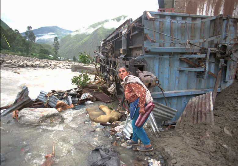 In this Jan. 15, 1998 file photo, a women sifts through rubble near her destroyed home after much of the town of Santa Teresa in Cuzco, was destroyed by a mudslide brought on by persistent rains attributed El Nino.  (AP Photo/Oscar Paredes, File)