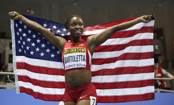 United States' Tianna Bartoletta celebrates with the US flag after winning the bronze in the women's 60m final during the Athletics Indoor World Championships in Sopot, Poland, Sunday, March 9, 2014. (AP Photo/Matt Dunham)