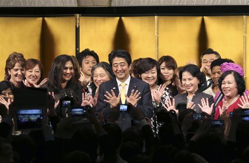 Japanese Prime Minister Shinzo Abe, center, poses for a photo with participants during a reception of WAW!, or the World Assembly for Women, in Tokyo, Friday, Aug. 28, 2015. More than 100 people from about 40 countries participated in the open forum for women. Japanese lawmakers approved a law Friday requiring large employers to set and publicize targets for hiring or promoting women as managers. The law approved by a vote of 230-1 in the House of Councillors is intended to promote greater gender equality and counter labor shortages that are arising as Japan's population ages and declines. The decision coincided with the international conference showcasing Abe's commitment to increasing the share of women in leadership positions to 30 percent. (AP Photo/Koji Sasahara, Pool)