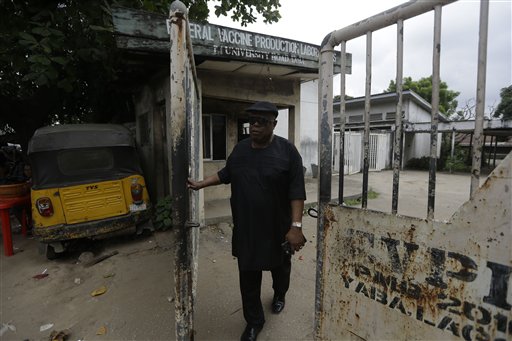 In this photo taken Saturday, Aug. 1, 2015, Felix Nwabueze, who was a quality control officer In the late 1970s at a laboratory in Nigeria where millions of smallpox vaccines were made, walk past the abandoned building in Lagos, Nigeria. International health officials are scrambling, without much success, to find meningitis C vaccines as an outbreak of the child-killing disease threatens to balloon into an epidemic. (AP Photo/Sunday Alamba)