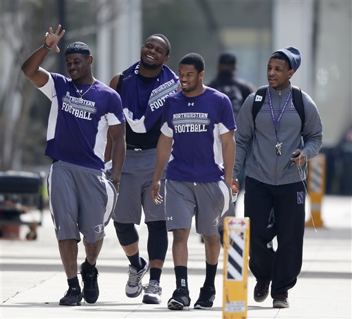 In this April 25, 2014, file photo, unidentified Northwestern football players walk between their locker room and McGaw Hall, where voting is taking place on the student athlete union question, in Evanston, Ill. The National Labor Relations Board has dismissed a historic ruling that Northwestern University football players are school employees who are entitled to form what would be the nation's first union of college athletes. The NLRB released its decision Monday, Aug. 17, 2015. The losing side does not have an option to appeal. (AP Photo/Charles Rex Arbogast, File)