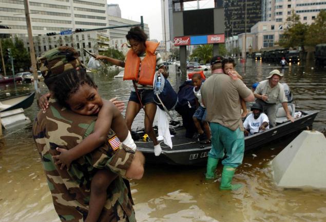 National Guard member Sgt. Ricky Wheelington (left) holds Tyrone Allen, 2, as he arrives for shelter at the Louisiana Superdome in New Orleans in the aftermath of Hurricane Katrina. Around 26,000 people took shelter in the Superdome as the hurricane made landfall. (Melissa Phillip/AP Photo)