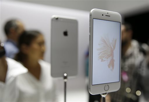 People look over the new Apple iPhone 6s models during a product display following an Apple event Wednesday, Sept. 9, 2015, in San Francisco. Apple staked a new claim to the living room on Wednesday, as the maker of iPhones and other hand-held gadgets unveiled an Internet TV system that's designed as a beachhead for the tech giant's broader ambitions to deliver a wide range of information, games, music and video to the home. (AP Photo/Eric Risberg)