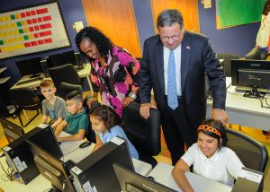 Six-time Olympic medal winner Jackie Joyner-Kersee (left) and David L. Cohen, the senior executive vice president of Comcast Corporation visit children in a computer lab. (Comcast)