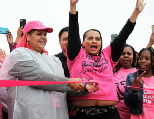 With her sister Satra to her left, Compton City Councilwoman Janna Zurita cuts the ribbon, starting the seventh annual Compton Walk For A Cure at Centennial High School Oct. 13. A morning rainstorm may have resulted in fewer participants than normal. ()