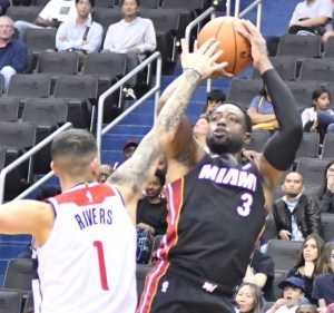 Miami Heat guard Dwyane Wade shoots over Washington Wizards guard Austin Rivers during the Wizards' 121-114 preseason win at Capital One Arena in D.C. on Oct. 5. (John De Freitas/The Washington Informer)