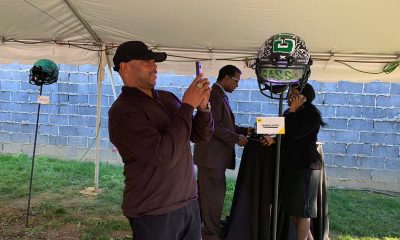 Cass Tech football coach Thomas Wilcher admiring the Xenith helmet created by former player Ndubisi Okoye.