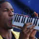Jon Batiste performs on the melodica.