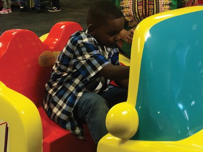 Erik “Doobie” Williams tests his skills on a racing game at Chuck E. Cheese. 