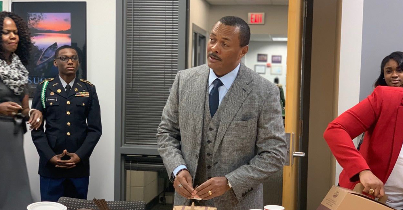 Detroit Cass Tech class of 1979 alum and Toyota executive Chris Reynolds making himself a cup of coffee while talking to current students of his former high school (michronicleonline.com)