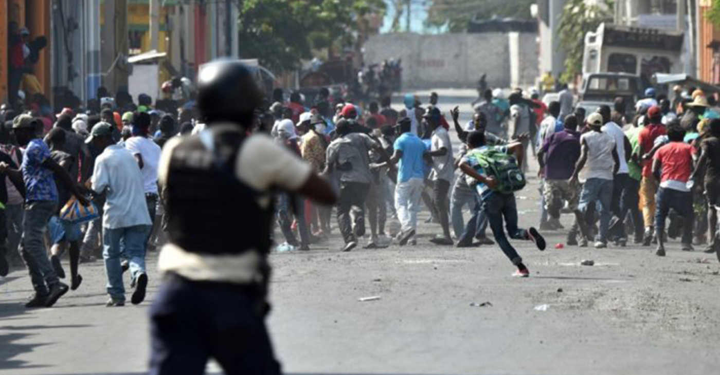 Demonstrators flee as Haitian police open fire during the clashes in the center of the Haitian capital Port-au-Prince on Feb. 13, 2019, the seventh day of protests against Haitian President Jovenel Moise that continue unabated. – Photo: Hector Retamal, AFP