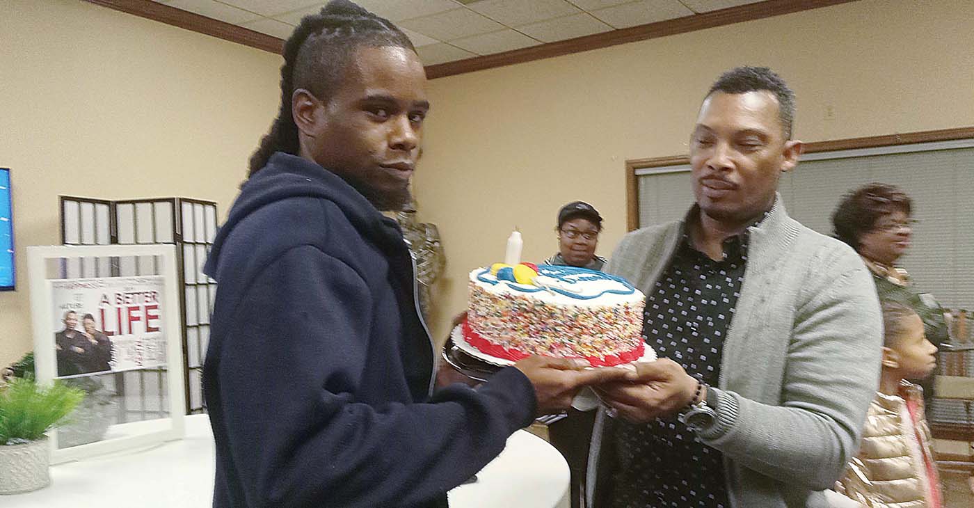 Description: Pastor Henry Lavender gives DeAndre Bramlett, who broke into Lavender’s church, something Bramlett said he’d never had – a birthday cake. (Photo: Dr. Sybil C. Mitchell)