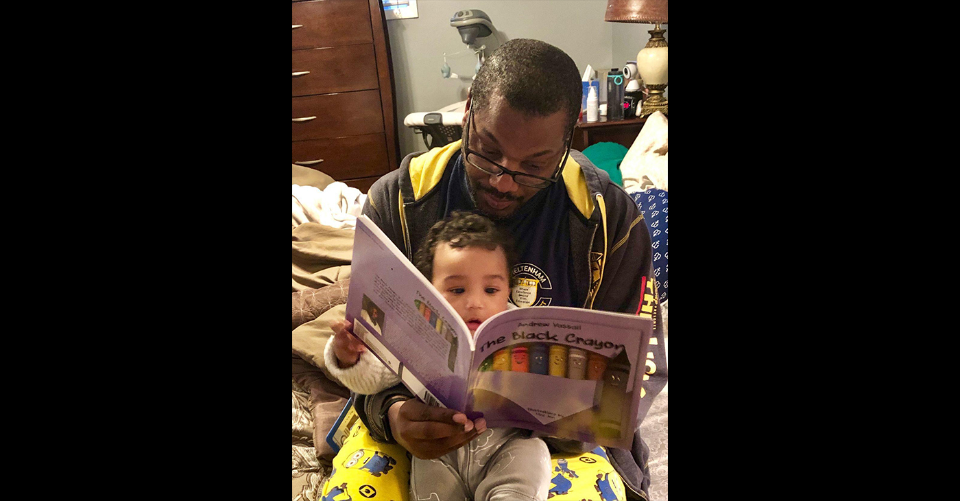 “The Black Crayon” author Andrew Vassall reads his book to his son, Shaan Ivan Vassall. The story encourages reading and teaches self-awareness and cultural awareness to young children. (Photo Courtesy of Andrew Vassal)