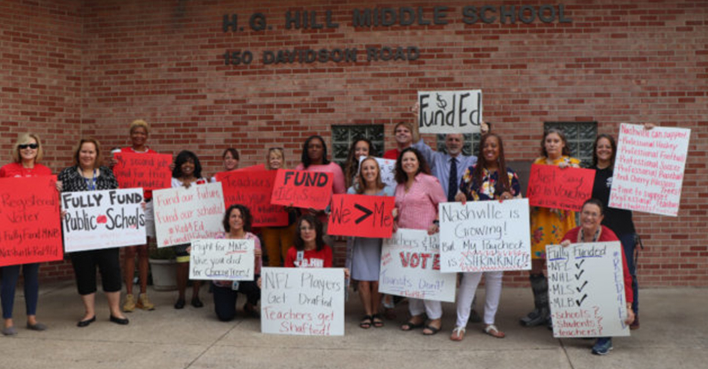 Wearing red, teachers at H.G. Hill Middle School pose with signs May 1, 2019. They want a raise six times more than the 3% Mayor David Briley has offered.