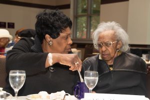 Thelma Ferbish, 70, stirs coffee for her mother Viola Harrison, 102, who was one of the centenarians honored at the D.C. Department of Aging and Community Living luncheon at the Kellogg Conference & Hotel in northeast D.C. on April 29. (Shevry Lassiter/The Washington Informer)