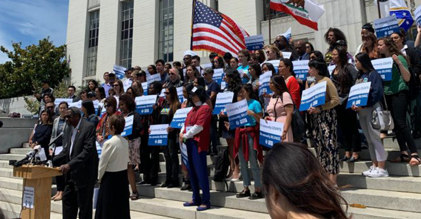 Standing on the steps of the Alameda County Superior Courthouse, dozens of people chant “Our Community Counts! Our Community Belongs!” followed by speeches from immigrant advocates, elected officials, and allies, Thursday, June 27. Photo courtesy of Alameda County Census.