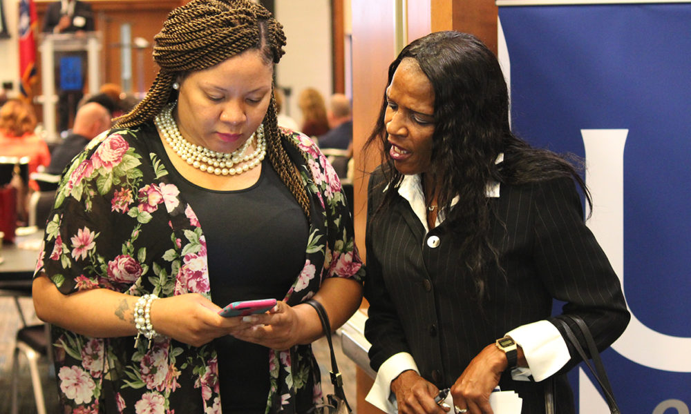 Lori Black (right) shares her information with a new contact interested in helping the 52-year-old ex-offender find work. The two met at a forum aimed at connecting employers with the formerly incarcerated. “My background don’t determine me,” a defiant but determined Black said. “Not today, it don’t.” (Photo: Lee Eric Smith)