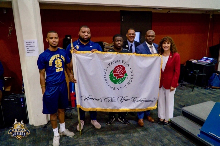 President Laura Farber (far right) presents ‘Human Jukebox’ Director of Bands Kedric D. Taylor (second from right) with the official Tournament of Roses banner. (Courtesy photo)