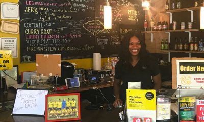 In this photo, Keacean Phillips, owner of Jamaican Homestyle Cuisine, poses behind the register at her restaurant located on North Killingsworth St. in Portland, Ore. (Photo by R. Dallon Adams)