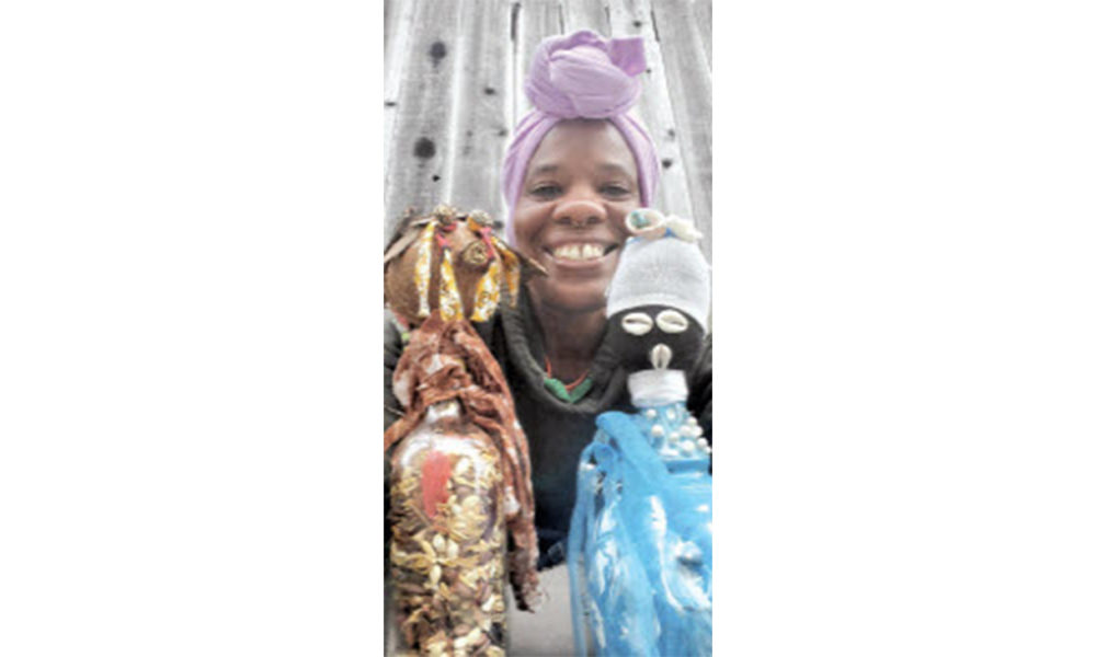 GoddessMother SupaQueen with two of her bottle doll creations. Photo courtesy of the artist.