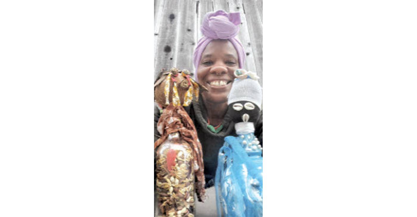 GoddessMother SupaQueen with two of her bottle doll creations. Photo courtesy of the artist.