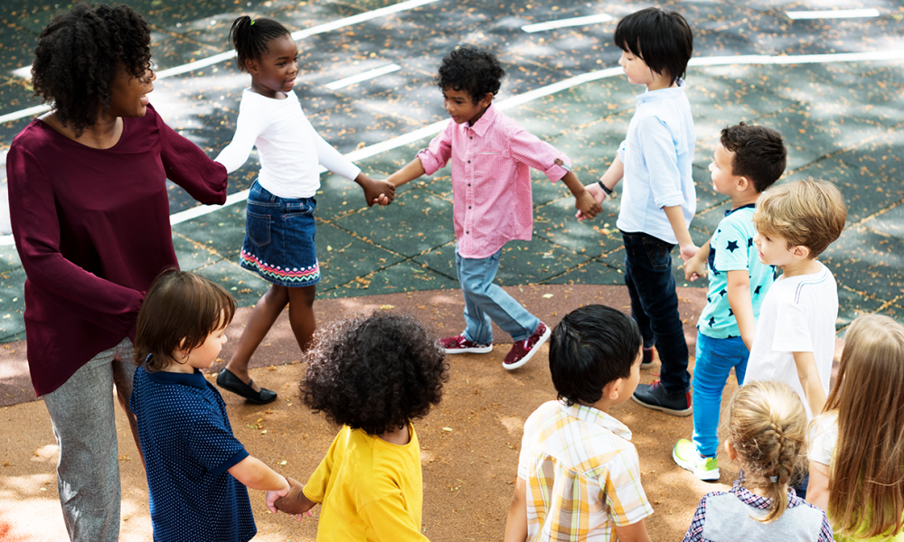 Group of diverse kindergarten students standing holding hands to (Photo by: Rawpixel)