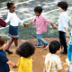 Group of diverse kindergarten students standing holding hands to (Photo by: Rawpixel)