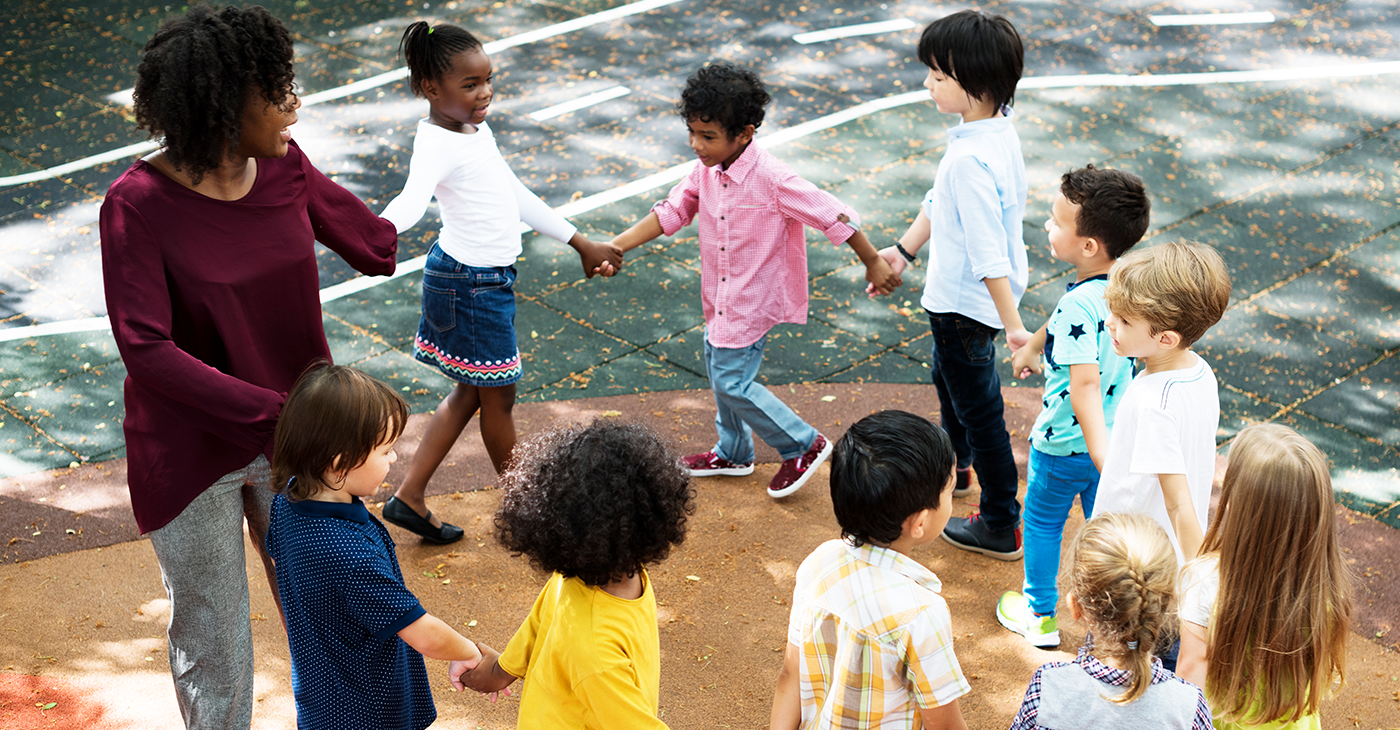 Group of diverse kindergarten students standing holding hands to (Photo by: Rawpixel)