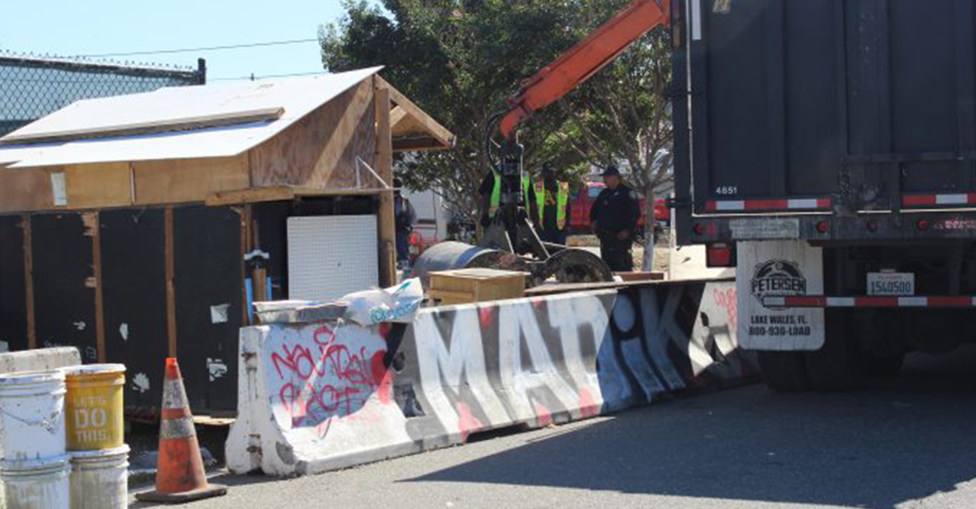 Under the direction of Mayor Libby Schaaf’s city administration, and with protection from OPD, Oakland’s Department of Public Works destroys homeless resident Tommy Alexander-Ayala’s self-made home that he’d used to temporarily house friends. (Photo by: Zack Haber).