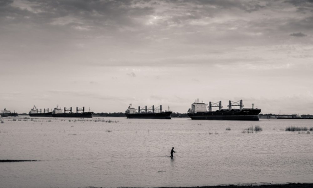 Fishing in the flooded Bonnet Carré Spillway with moored tankers in background, near Norco (detail); 2015; © Richard Sexton; The Historic New Orleans Collection, 2015.0364.51