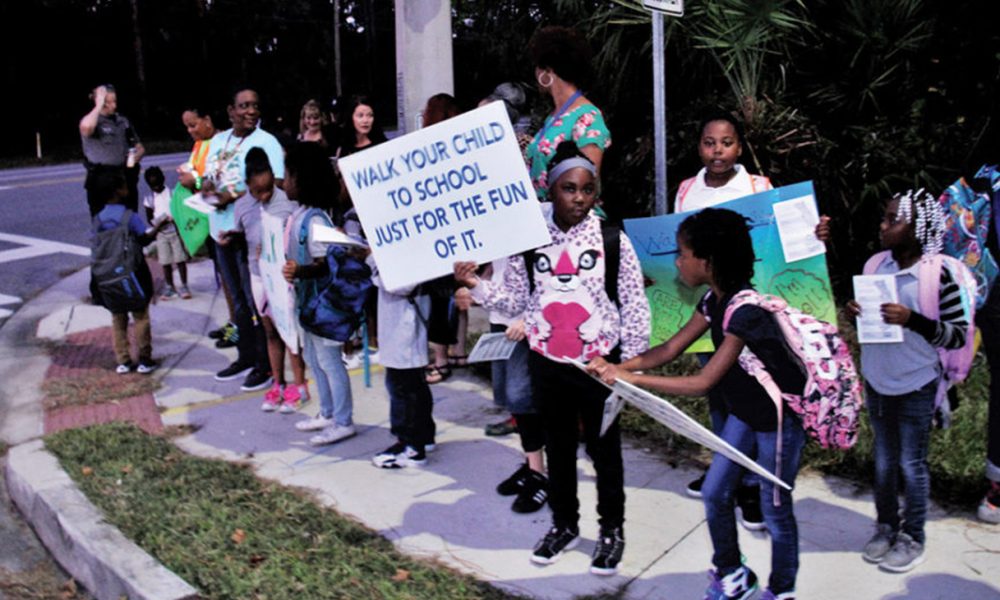 A group of Palm Terrace Elementary School students wait for adults to walk with them on the International Walk to School Day (Photo by: Duane C. Fernandez Sr. | hardnottsphotography.com)