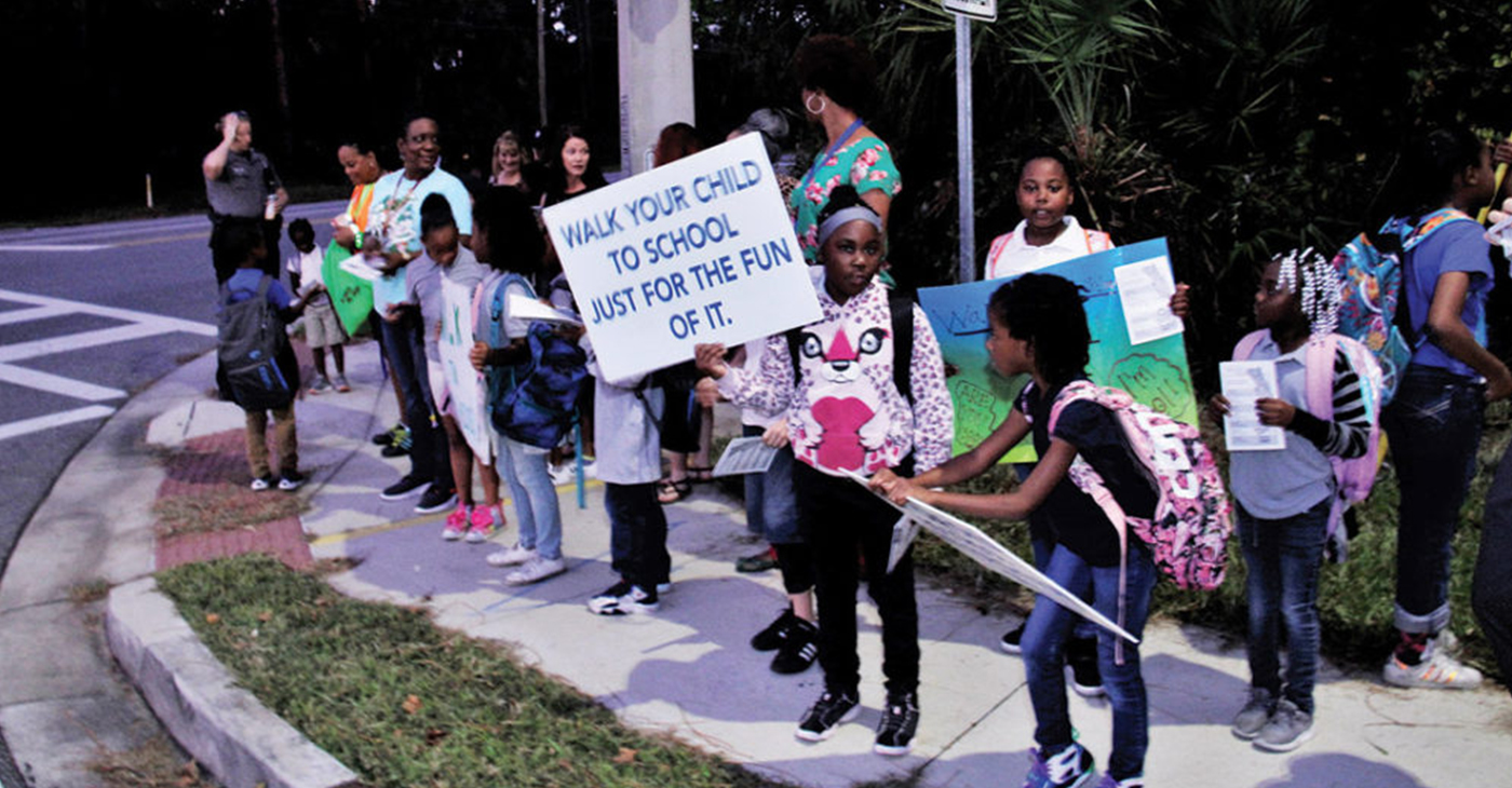 A group of Palm Terrace Elementary School students wait for adults to walk with them on the International Walk to School Day (Photo by: Duane C. Fernandez Sr. | hardnottsphotography.com)