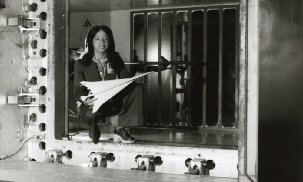 Informal portrait of NASA engineer Christine M. Darden. Darden is posed holding a wind tunnel model of a proposed aircraft while kneeling inside the test section of a wind tunnel at the NASA Langley Research Center, Hampton, Virginia. (Photo: National Aeronatics and Space Administration [NASA] / Wikimedia Commons)