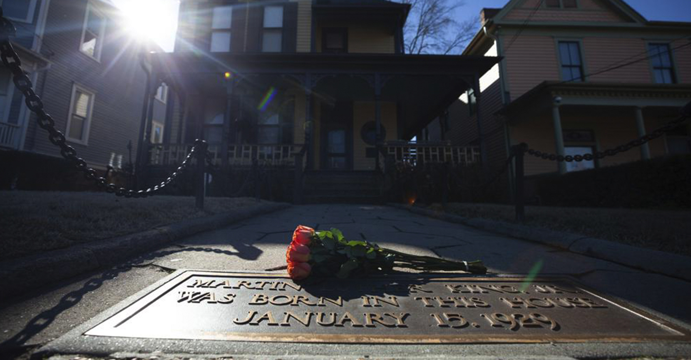 FILE - Flowers lay in front of the birthplace of Dr. Martin Luther King, Jr., on Jan. 18, 2021, in Atlanta. The annual Martin Luther King Jr. service is set to be held at his old congregation in Atlanta. (AP Photo/Branden Camp, File)