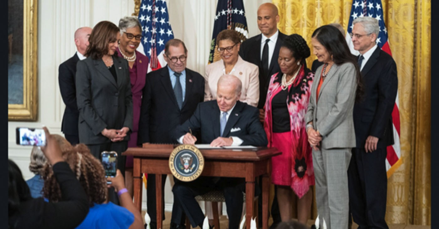 Karen Bass stands behind President Joe Biden as he signs an executive order on policing in the presence of Vice President Kamala Harris, far left, and other members of the House of Representatives and Senate. Facebook photo.