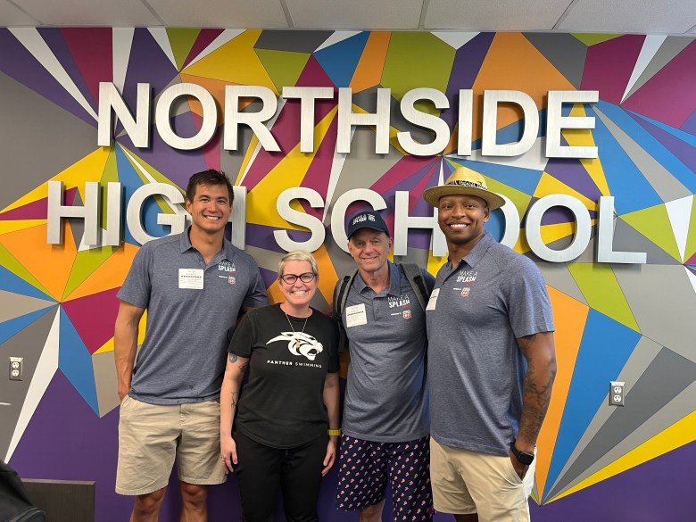 Olympians Nathan Adrian (far left) and Cullen Jones (far right) stand with two people against a multi-color backgorund with the words Northside High School on it