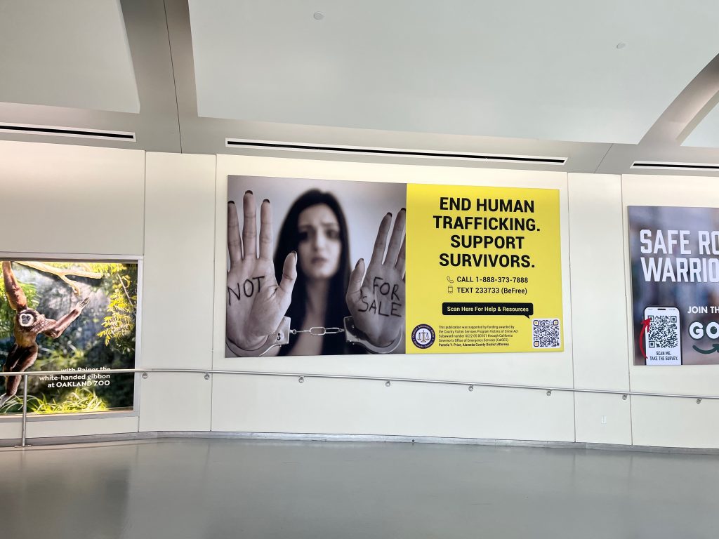 A billboard hung along a wall that can be easily seen by trafficking victims at Oakland International Airport. Photo by Magaly Muñoz.